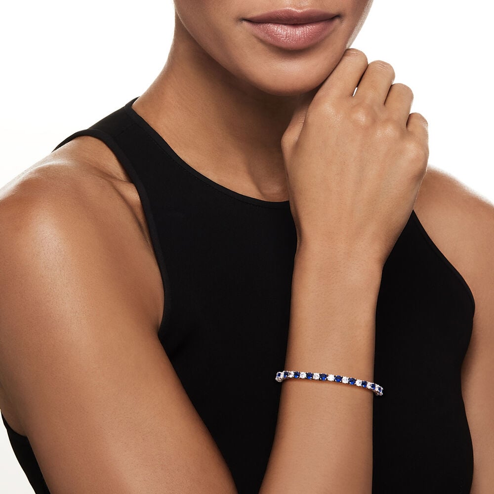 Woman wearing a blue and silver bracelet on a white background